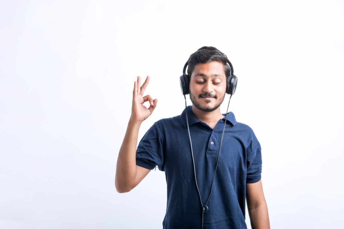 man wearing wired headphones OK symbol