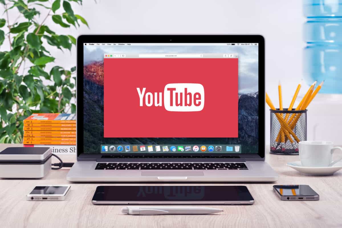 YouTube is available on web, mobile, smart TVs, and more. YouTube logo displayed on a MacBook