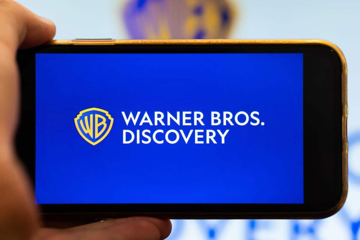 Warner Bros. Discovery logo on iPhone screen.